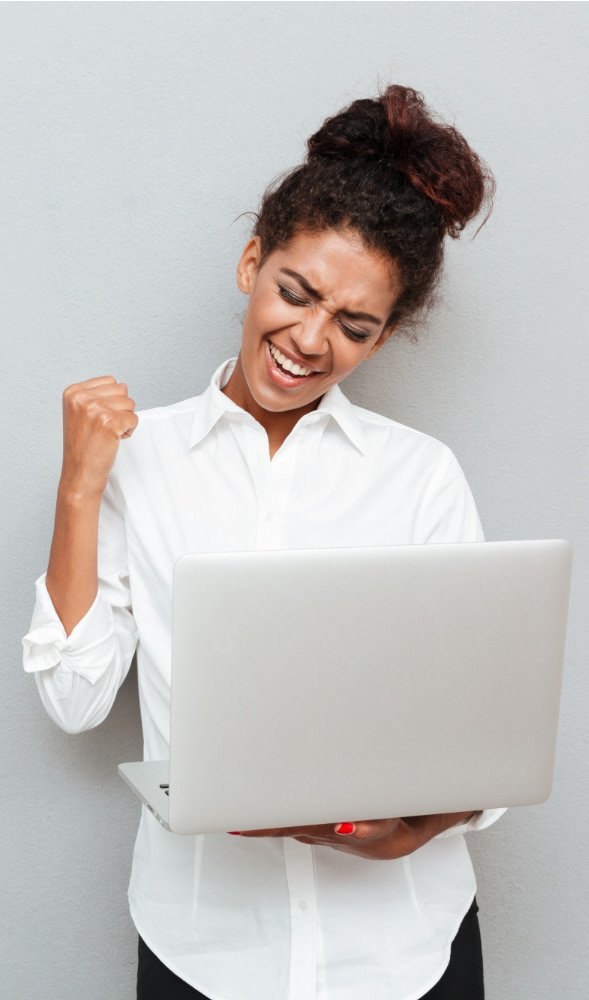 Excited woman celebrating results on her laptop